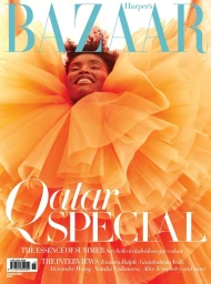 Close-up portrait of a smiling Black woman surrounded by large orange ruffled tulle fabric for a magazine cover.
