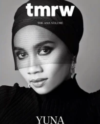 Black and white editorial portrait of a woman wearing a black headwrap and mesh veil styled by Aquiles