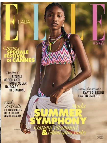 Elle Italia magazine cover featuring an African American model in a bikini and sarong, posing outdoors against a blurry beach background.