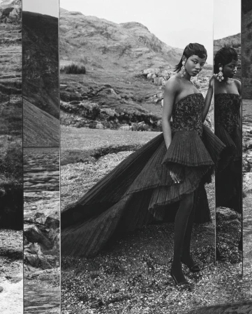 Fashion shot of a Black woman in a black couture gown with a mountain background, reflected in a tall mirror in a black and white photograph.