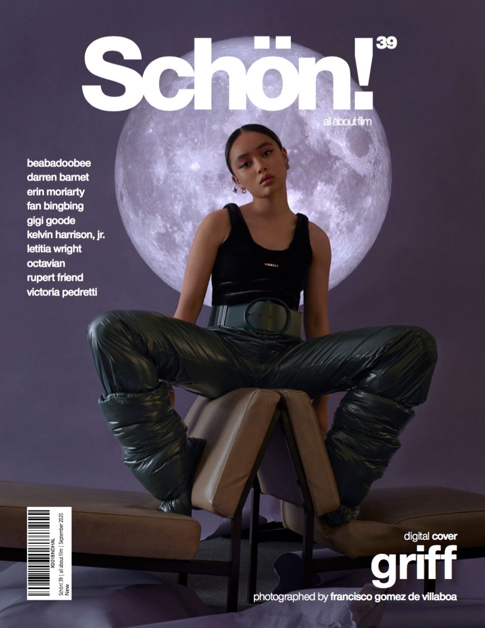 Magazine cover featuring a woman in a black top and shiny green pants, seated on a prop with a moon backdrop, promoting Schon!