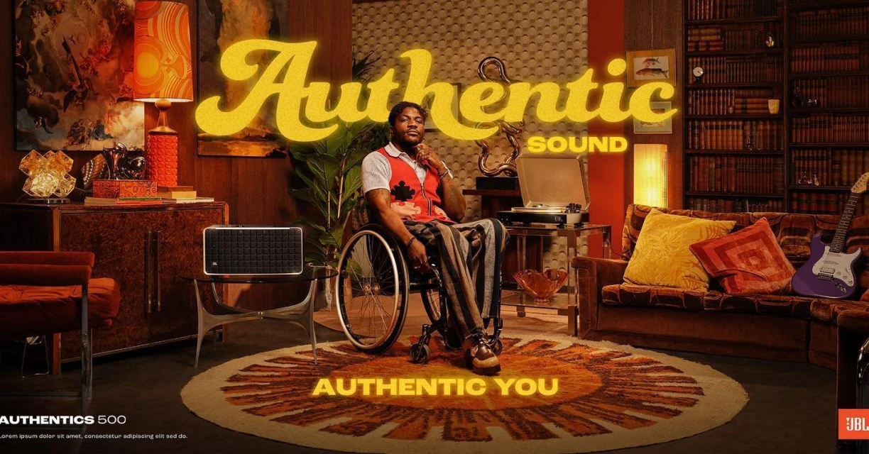 Man in wheelchair in retro living room setting next to JBL Authentics 500 speaker, vintage furniture, and 'Authentic Sound' text overlay.