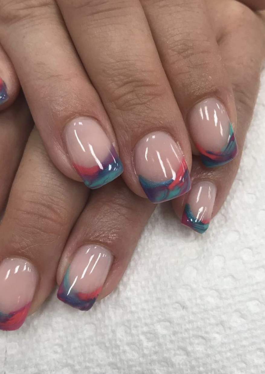 Close-up of manicured nails with a modern French design featuring pink and teal accents, showcasing beauty and nail art.