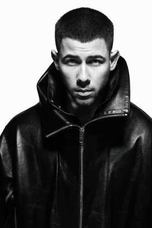 Portrait of a man in a black leather jacket against a white background, captured in a medium shot with sharp focus.