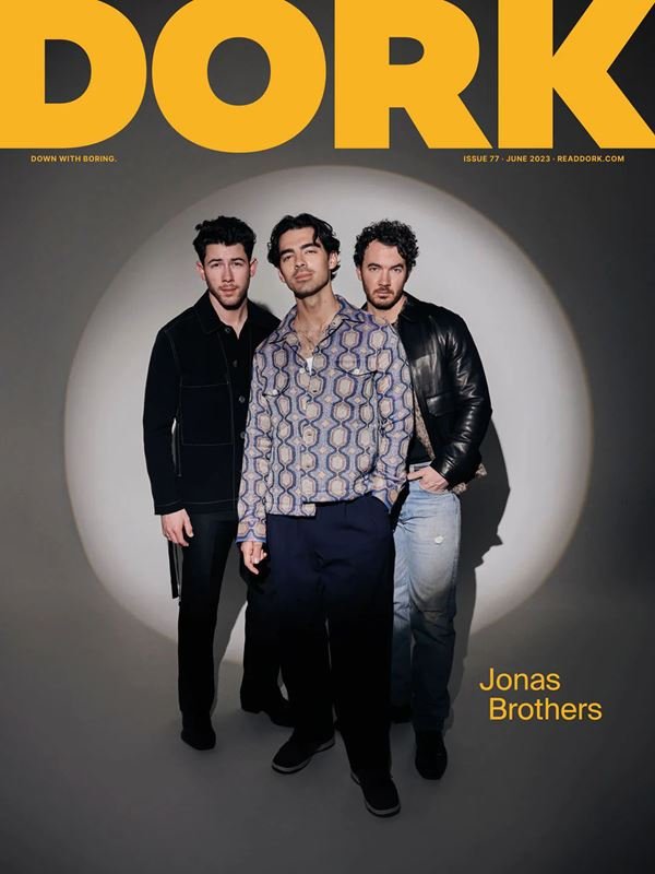 Magazine cover featuring Jonas Brothers in stylish attire against a spotlight backdrop, with 'DORK' title and issue details.