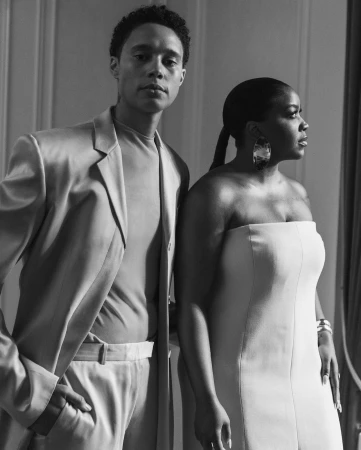 Black and white portrait of a man in a light suit and a woman in a strapless dress styled by Courtney Mays.