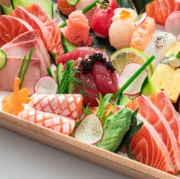 Close-up of a Japanese sushi and sashimi catering platter featuring sliced salmon, tuna, shrimp, and pickled ginger by FeeDee in Sydney.