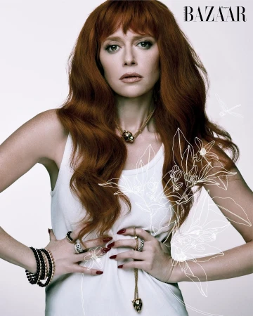 Red-haired woman in a white tank top with jewellery styled by Cristina Ehrlich against a plain background