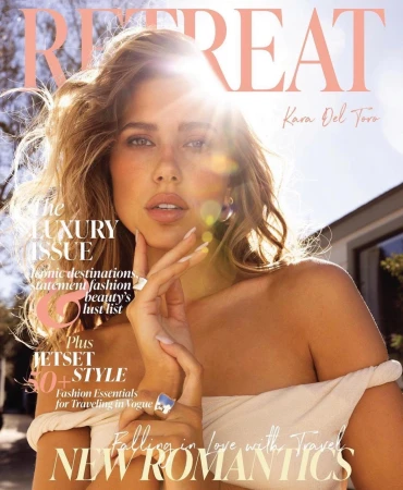 Magazine cover featuring a woman with sunlit blond hair, wearing an off-the-shoulder top, against a blurred background.
