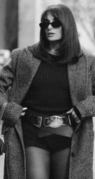 Monochrome fashion portrait of a woman in sunglasses and a herringbone coat styled by Danielle Alix