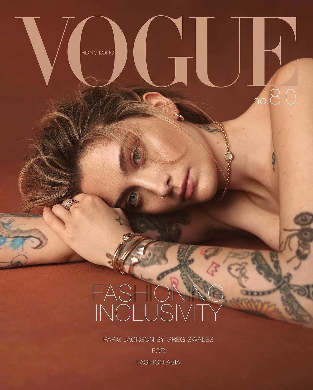 Vogue Hong Kong cover featuring Paris Jackson with tattoos, jewelry, and a caramel backdrop, photographed by Greg Swales for Fashion Asia.