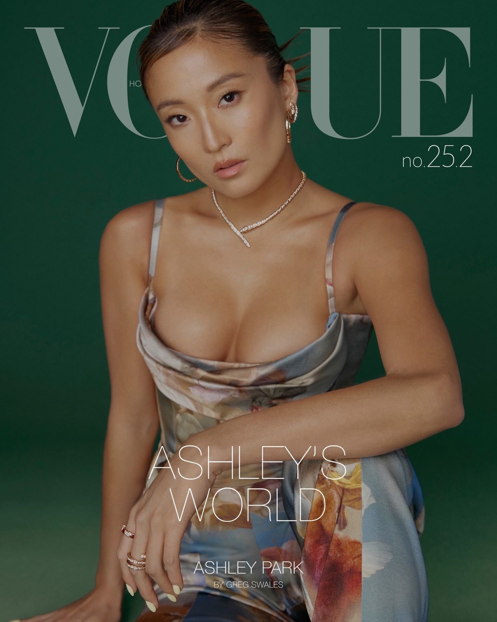 Ashley Park on the cover of Vogue Hong Kong, wearing a patterned top, gold hoop earrings, and a diamond necklace against a green backdrop.