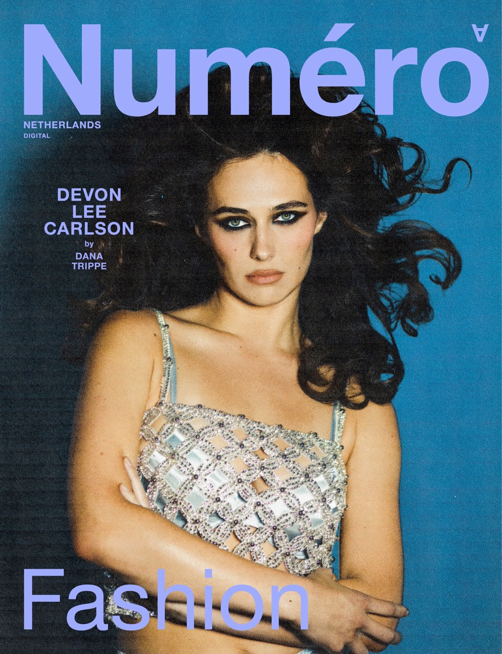 Magazine cover featuring Devon Lee Carlson wearing a silver top against a blue background with 'Numero Netherlands Digital' text.