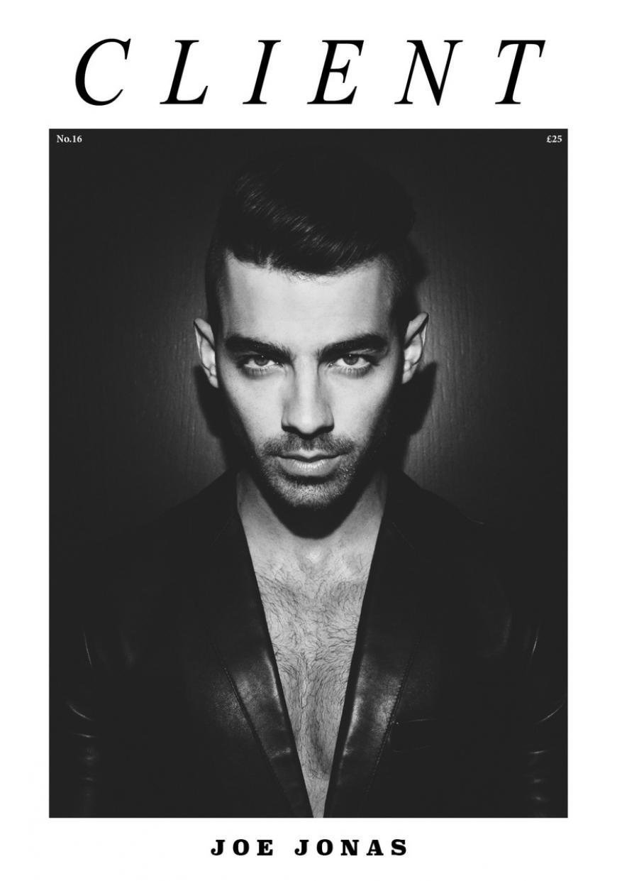 Black-and-white fashion portrait of a man in a suit jacket against a dark background. Client magazine cover. Joe Jonas.
