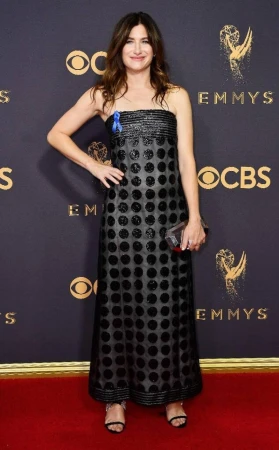 Kathryn Hahn poses on a red carpet in a black polka dot gown at the 69th Primetime Emmy Awards. She holds a clutch.