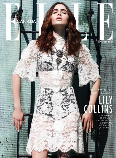 Magazine cover featuring Lily Collins in a white lace dress, standing against a weathered green wall with ladder elements. Fashion and celebrity.