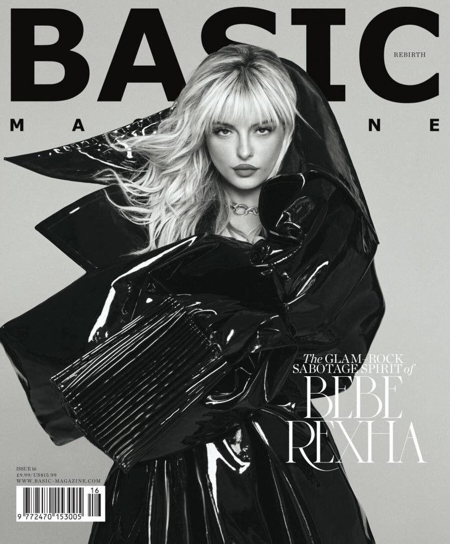 Black and white magazine cover featuring Bebe Rexha in a shiny black coat, against a gray backdrop with the magazine's name, BASIC.