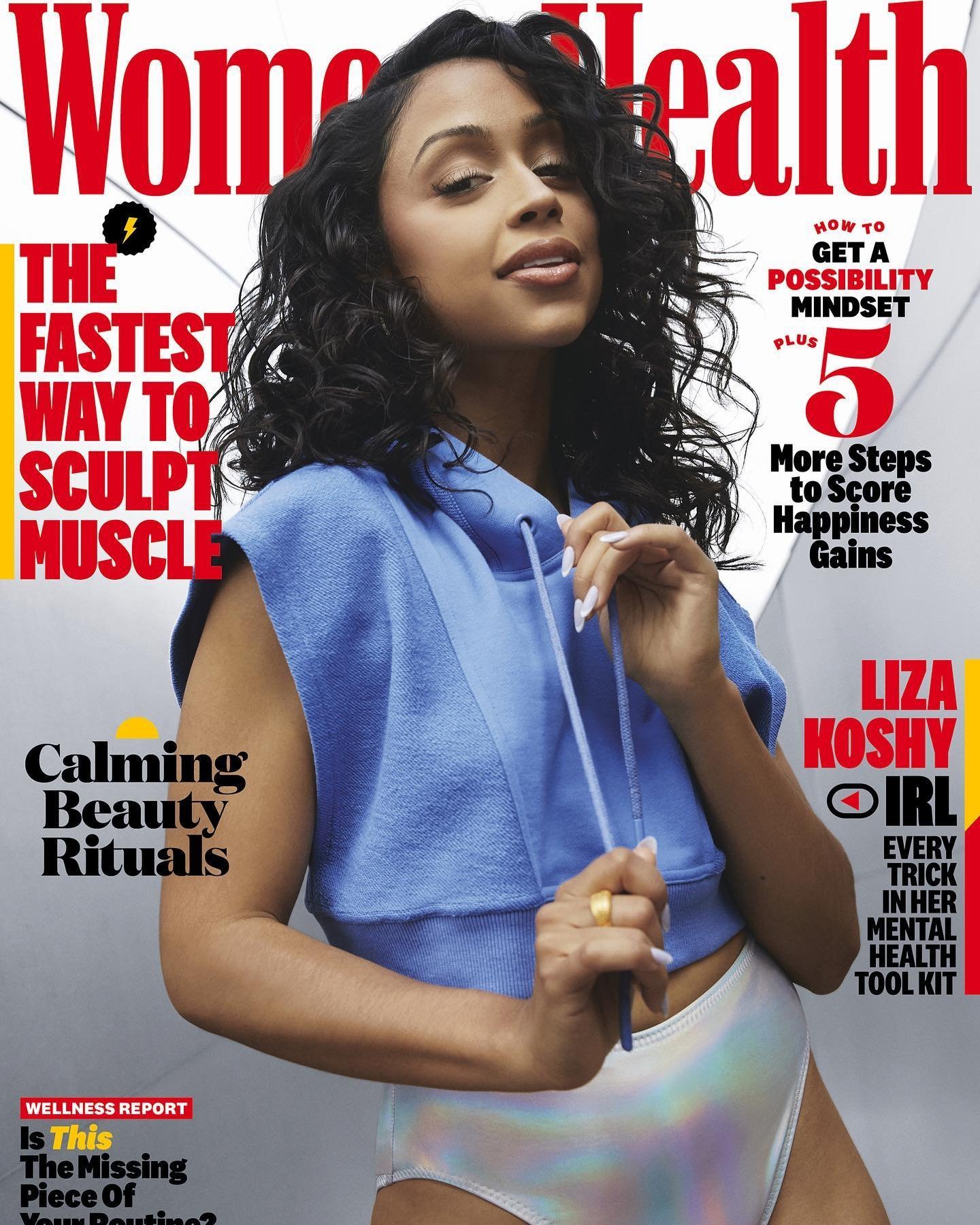 Liza Koshy on the cover of Women's Health magazine, wearing a blue hooded sweatshirt and a shimmering bathing suit bottom.