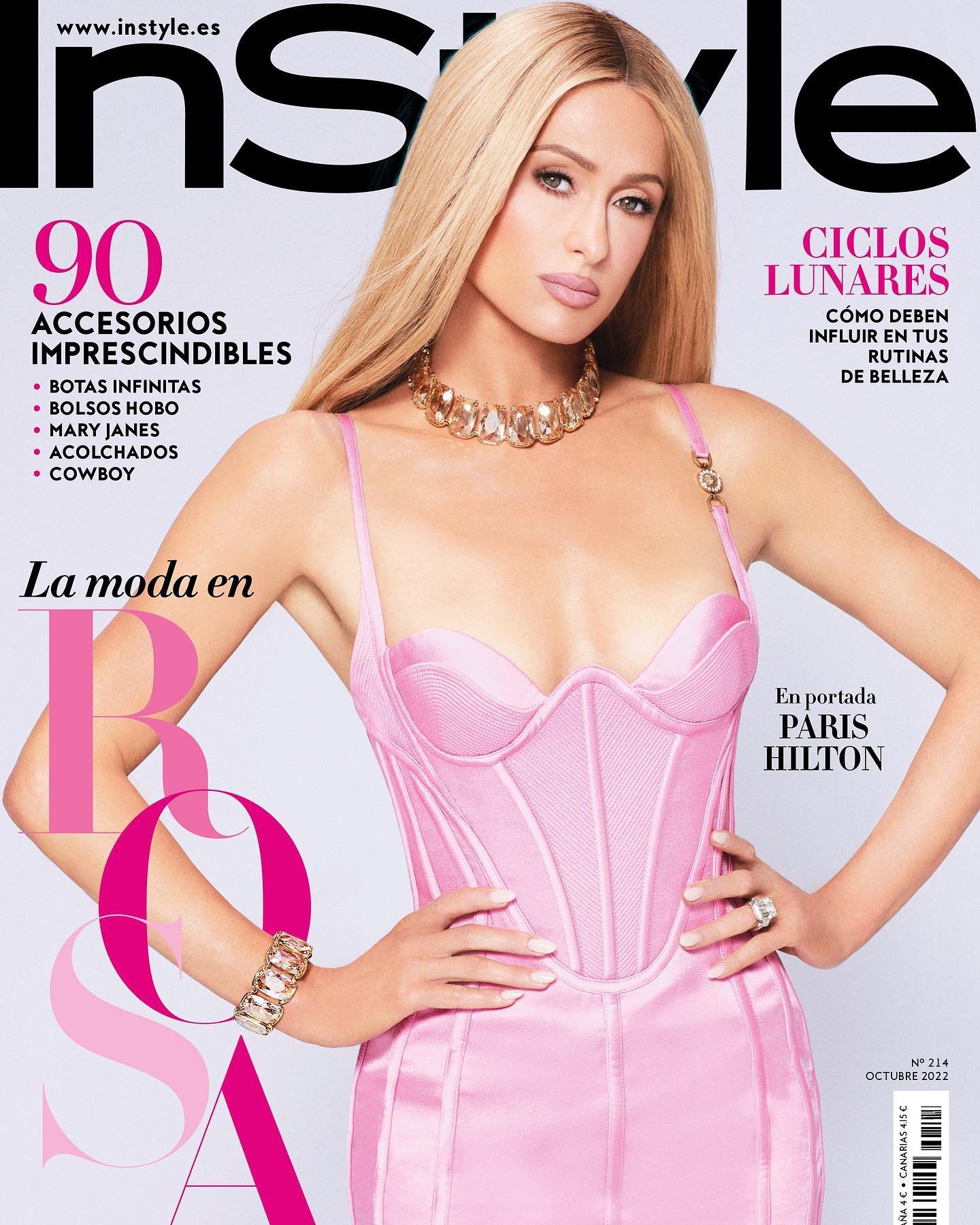 Magazine cover featuring Paris Hilton in a pink dress, adorned with a gold necklace and bracelet, against a light background. 