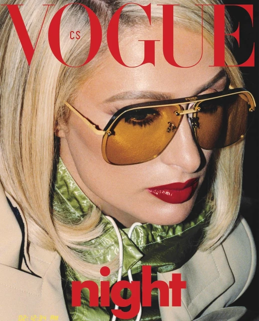 Vogue cover featuring a close-up of a blonde woman wearing gold aviator sunglasses, red lipstick, and a tan jacket over a green top.