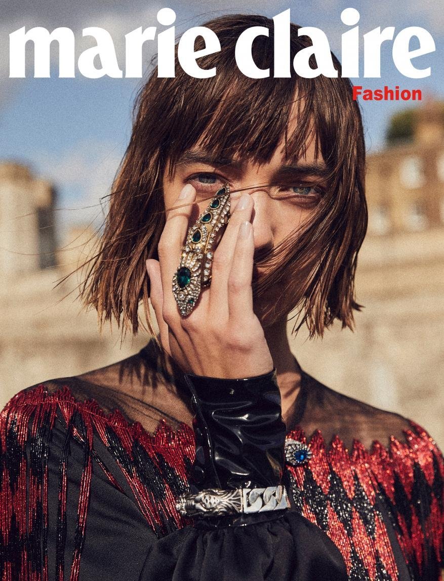 Fashion magazine cover featuring a woman with a large ring on her finger, wearing a red and black patterned top, and 'Marie Claire' masthead.