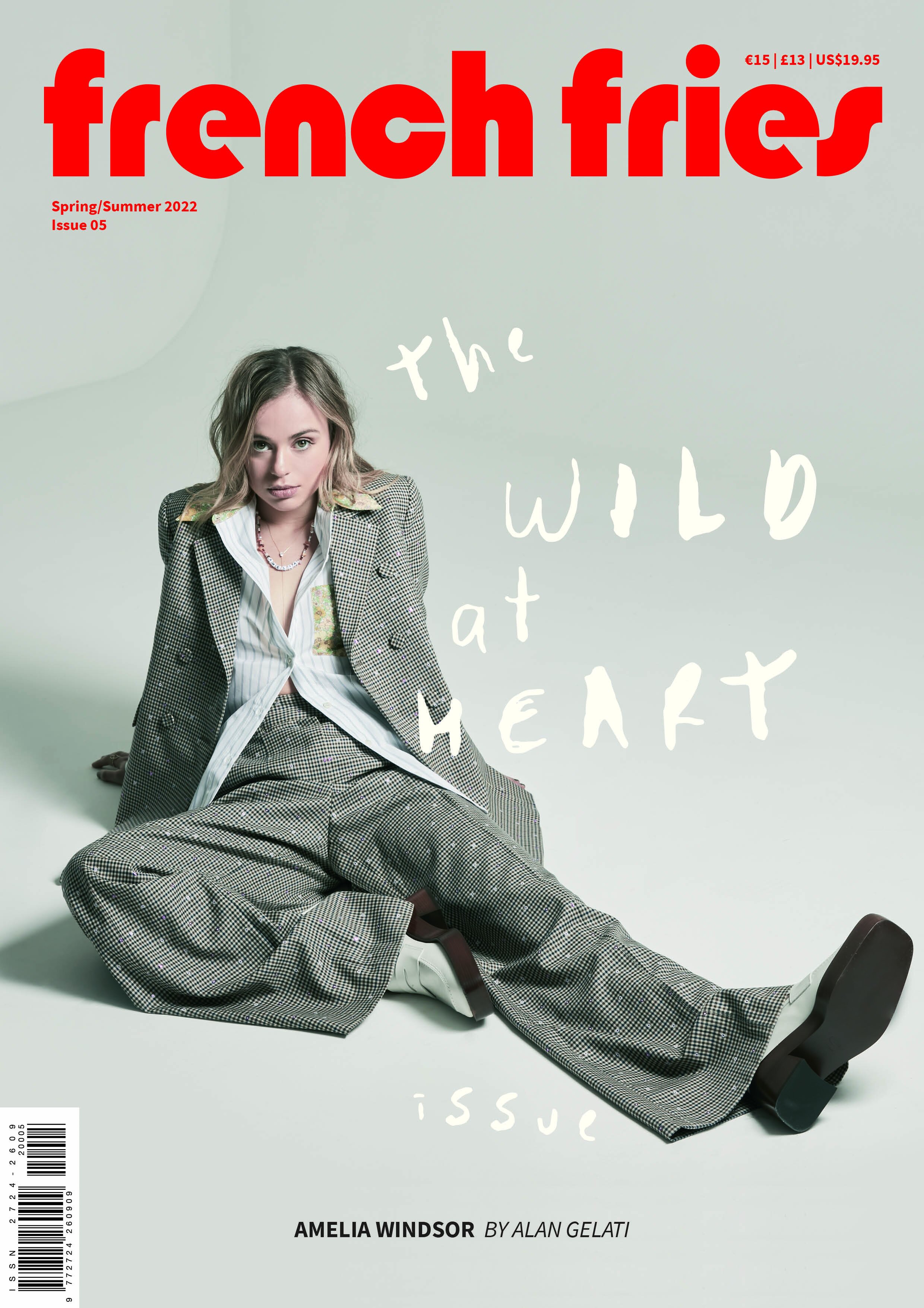 Magazine cover featuring a young woman in a sparkling grey suit, sitting with legs outstretched, on a light grey background with red title text.