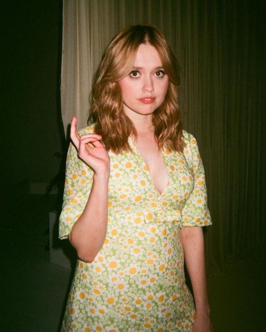 Portrait of a blonde woman wearing a floral dress, posing indoors with soft lighting, creating a vintage-inspired fashion image.