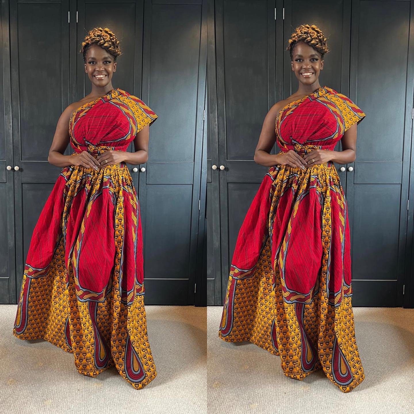 Black woman wearing a red and yellow patterned one-shoulder dress with braided updo hair standing indoors