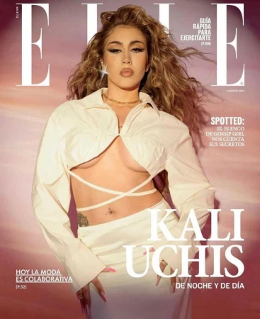 Elle magazine cover featuring Kali Uchis. Uchis wears a white crop top and skirt. The image has a soft, diffused light and a warm color grade.