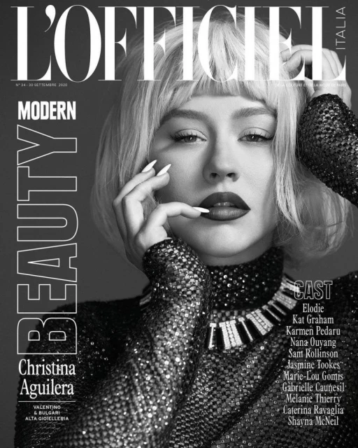 Black-and-white L'Officiel cover featuring Christina Aguilera in a shimmering dress, platinum wig, bold makeup, and manicured nails.