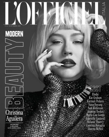 Black-and-white L'Officiel cover featuring Christina Aguilera in a shimmering dress, platinum wig, bold makeup, and manicured nails.