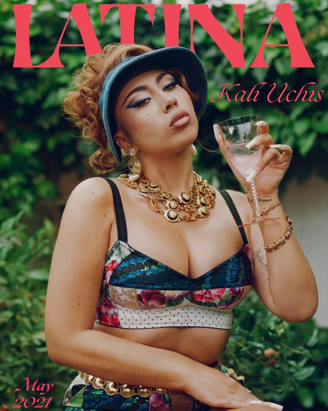 Latina magazine cover featuring Kali Uchis, May 2021 issue. She is holding a glass, wearing gold jewelry and a blue visor, set against a green backdrop.