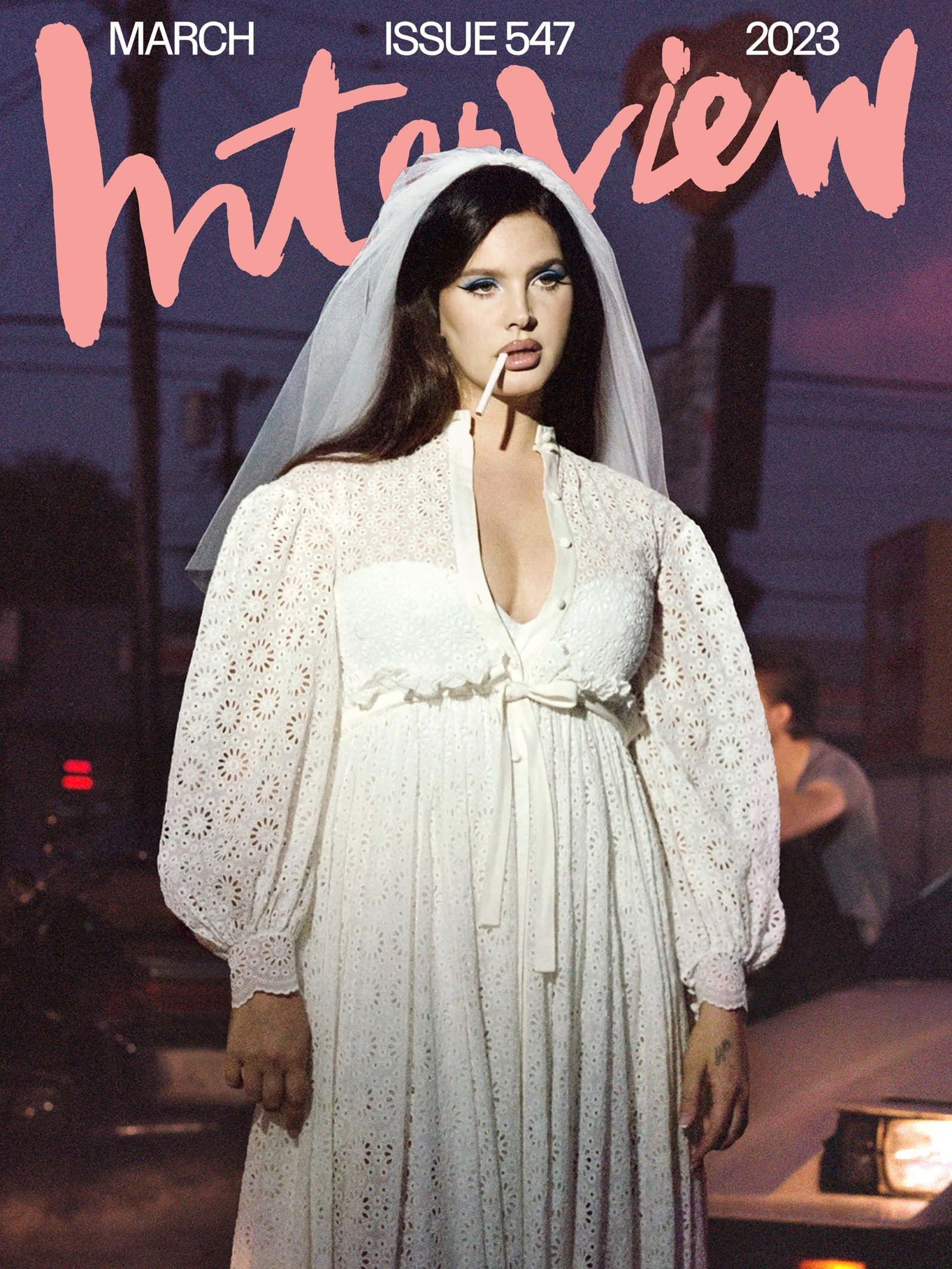 Lana Del Rey on Interview Magazine cover, March 2023 issue, wearing a white lace dress, veil, and holding a cigarette.