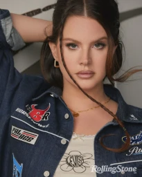 Portrait of Lana Del Rey wearing a denim shirt with patches and a white top, styled by make-up artist Etienne Ortega.