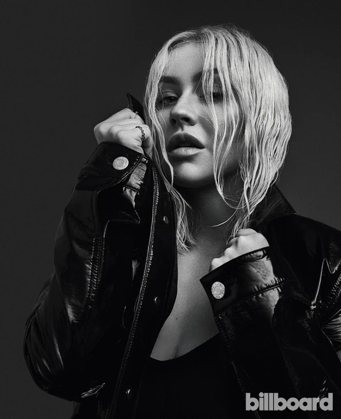 Monochrome portrait of Christina Aguilera with wet hair wearing a glossy patent leather jacket