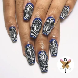 Close-up of hands displaying long square nails with intricate black and white optical illusion swirl art and blue borders.