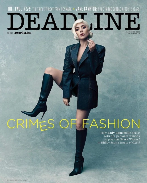 Lady Gaga poses on a magazine cover in a dark jacket, short bottoms, and black high heel boots. She's framed against a soft gray backdrop.