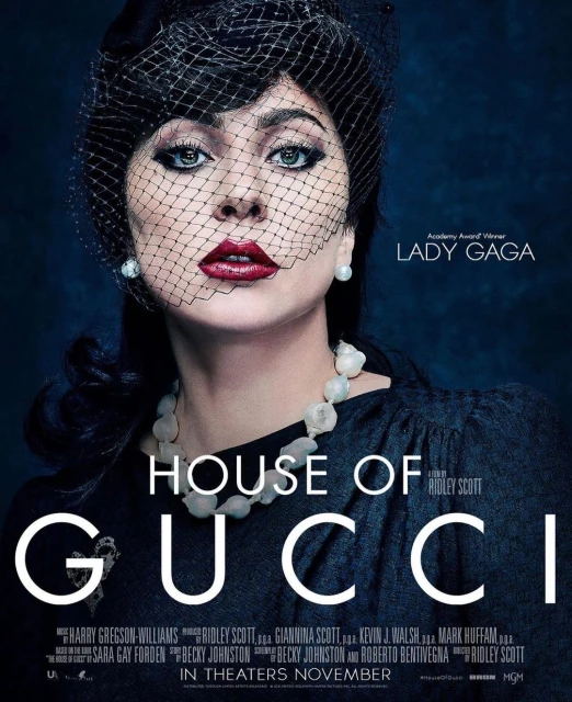 Movie poster featuring Lady Gaga for the film 'House of Gucci', wearing a black dress, pearl earrings and necklace, and a hat with netting.