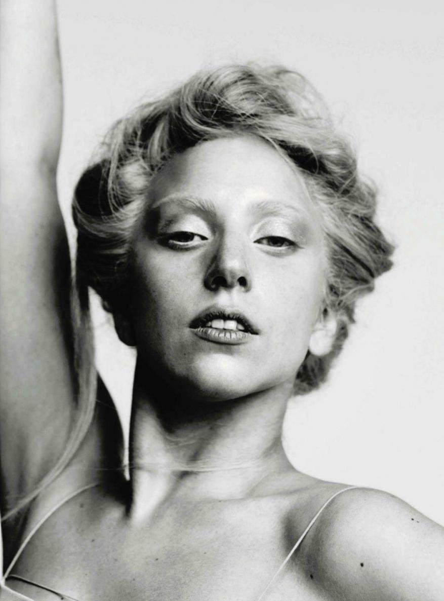 Black and white portrait of a woman with fair skin, light eyebrows, and light hair, gazing directly at the camera with a subtle expression.