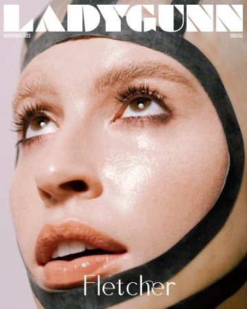 Ladygunn Magazine cover featuring a close-up of Fletcher, eyes looking up, wearing a black latex hood. Magazine text visible.