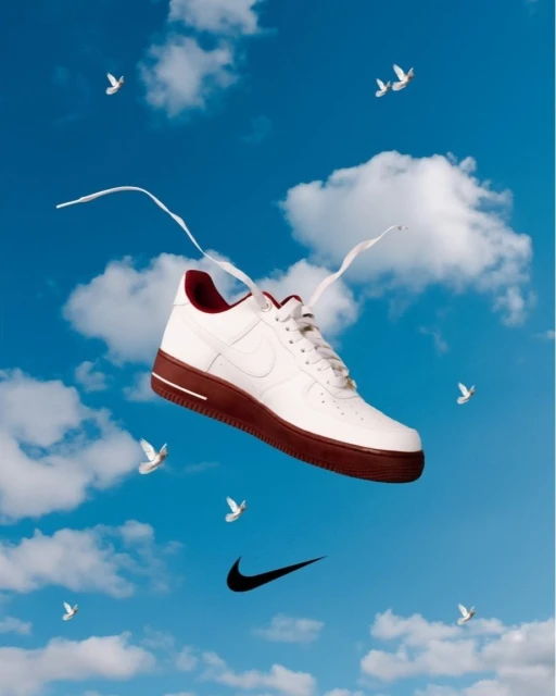 Nike Air Force 1 sneaker in a sky filled with clouds and doves, floating next to the Nike swoosh logo. White laces spread out.