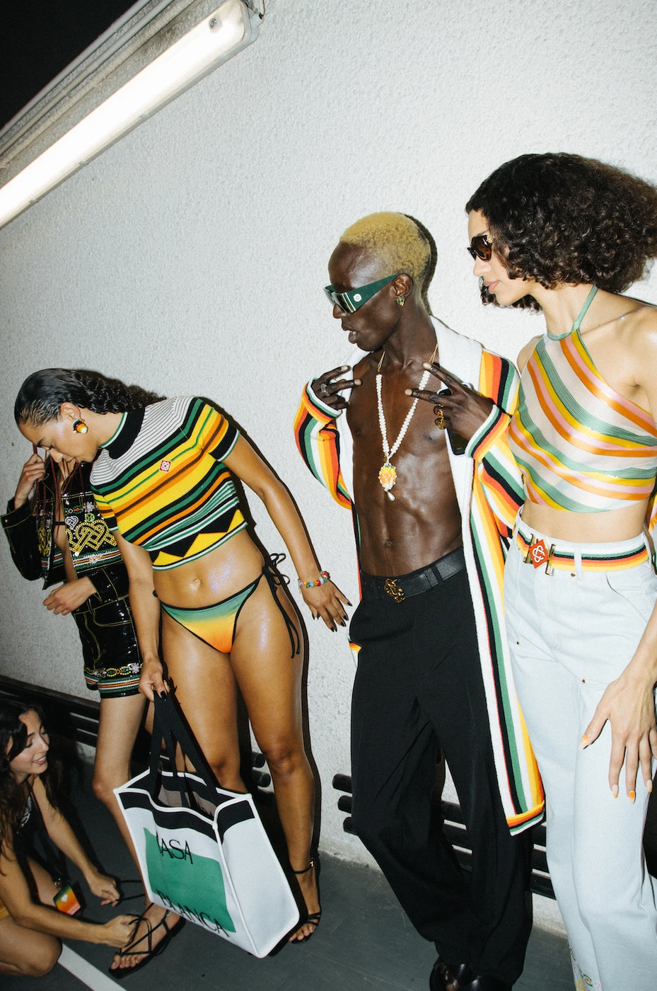 Group of four models posing outdoors against a pale wall, captured by photographer Gabriel Perez Silva.
