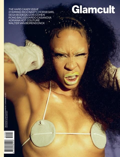 Glamcult magazine cover featuring a woman with dark hair and green lipstick, wearing a white string bikini and gloves against a blue background.
