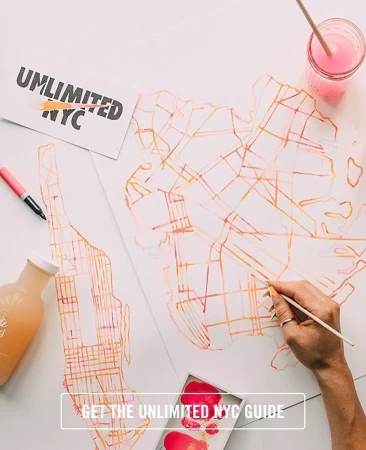Overhead shot of an artist painting a map of New York City with pink and orange watercolors, using a brush on white paper, with visible paint supplies.