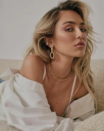 Close-up portrait of a woman wearing a white shirt and gold chain necklace with makeup by Jacinta Spencer.