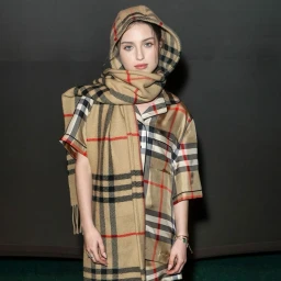 A young woman wearing a matching plaid hooded scarf and outfit by makeup artist Jacinta Spencer