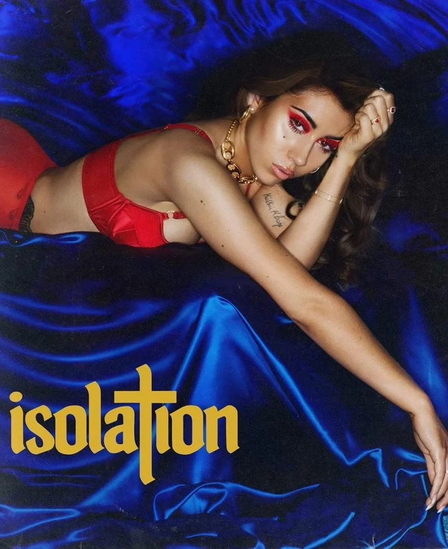 A woman with red eye makeup and a red bra top lying on a silky blue background. Image includes the word 'isolation' in yellow text.