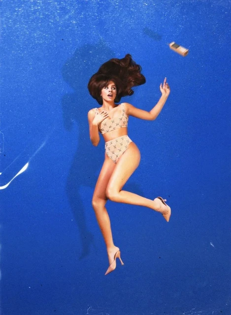 Woman in patterned bikini and heels suspended against a blue background with a falling object. Fashion and beauty concept.