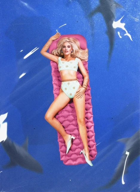 Blonde woman in a bikini lying on a pink pool raft in blue water with sharks, wearing gold jewelry and white high heels.