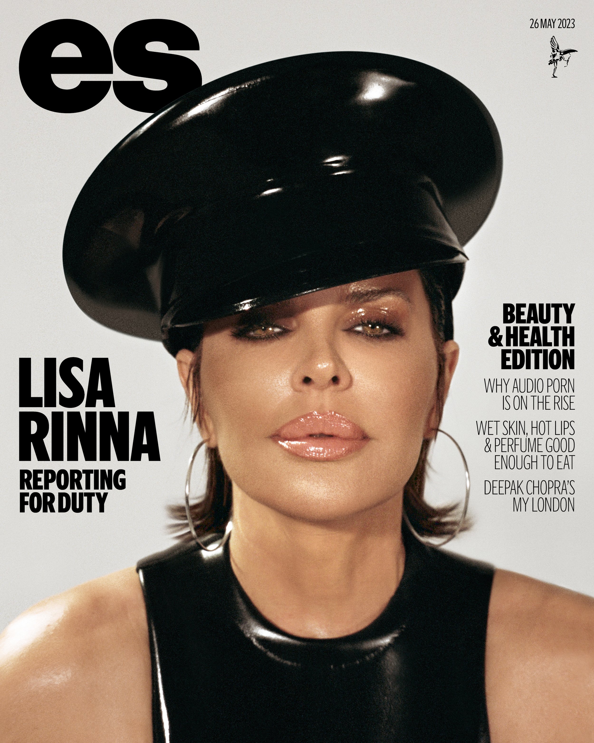 Close-up portrait of Lisa Rinna on a magazine cover, wearing a black patent leather hat and top, glossy lips, and silver hoop earrings.